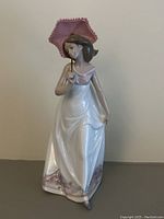 Front angled view of Lladro Afternoon Promenade figurine showing the lady with parasol and flowing dress.