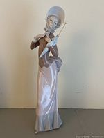 Front view of Lladro Coquetry figurine showing full figure and closed umbrella.