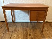 Frontal view of desk showing top surface, legs, and drawer unit