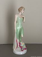 Front view of the Royal Doulton Monte Carlo figurine in a green dress with floral accents on base.