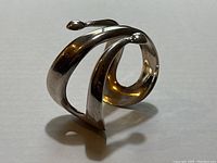 Side angle showing the spiral structure and rounded ends of the sterling silver cuff bracelet.