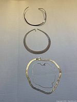 Four sterling silver necklaces laid out on a white surface showing the different styles.