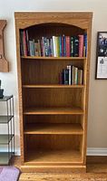 Front view showing the full bookshelf with books on the top two shelves and empty bottom shelves.