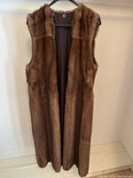Front view of full-length brown mink fur vest on hanger