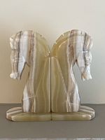 Front view of the pair of onyx horse head bookends showing symmetrical profiles and smooth polished natural onyx texture.