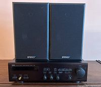 Front view of Yamaha RX-360 stereo receiver with two Energy Eclipse speakers positioned on top.