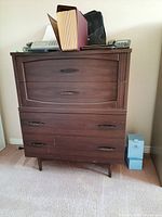 Full front view of wood dresser with 4 drawers, displaying condition and items on top