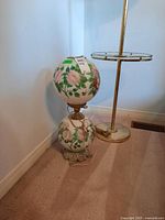 Full view of the vintage floral glass shade lamp showing two globe shades, painted with pink and red flowers, sitting on ornate metal base with electrical cord visible.