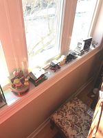 Ten decorative miniatures displayed on a window ledge including a Garfield and Odie music box and vintage car miniatures.