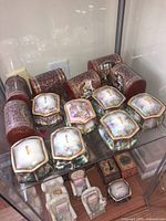 Photo showing most of the decorative music boxes including Thomas Kinkade and Jurgen Sholz with visible winding keys and detailed painted artwork.