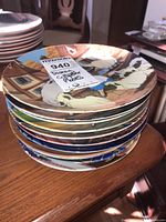 Stack of 12 Disney collectible decorative plates viewed from side, showing the collection of plates together.