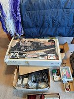 Whole lot including unopened train set box, box with controller, tracks, and model cars in packaging.