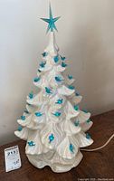 Front view of the ceramic Christmas tree showing overall shape, blue bird decorations, and blue star topper.