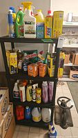 Image showing full utility shelf stocked with various cleaning supplies including bleach, dish soap, baking soda, SOS pads, garbage bags.
