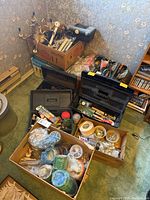 Full view of lot showing black and gray toolboxes with hand tools, and boxes filled with tape rolls and metal hardware items.