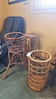 Three rattan and bamboo stands arranged on floor near window and chair