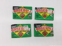 Four unopened packs of 1989 Bowman Baseball Bubble Gum Cards laid out flat front side visible, showing packaging details.