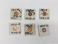 6 US Lincoln Penny collectible coins in individual cardboard holders labeled with year and mint mark, showing various years including 1935, 1957, 1960, 1961, 1971, and 1975.