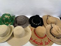 Overview photo showing all 8 assorted summer sun hats: various brim sizes, styles, colors including beige, brown, black, and green sequined cowboy hat with shamrocks.