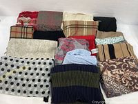 Lot of 17 scarves laid out showing variety in colors, patterns, and fabrics