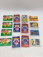 Top-down view of assorted unopened and opened MLB baseball card packs plus a couple of loose cards