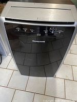 Front view of Honeywell MN10CES portable air conditioner showing control panel and brand logo.