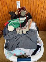 Mens clothing pile with gloves, shorts, T-shirts, and vintage brown umbrella. Size large 34 indicated.
