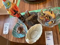 Wide shot showing the candy dish, shoe figurines, horse figurines, and shell dish on a table