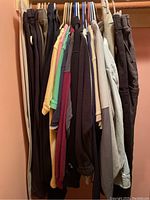 Men's assorted jerseys and jackets hanging on a clothing rack in assorted colors