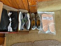 Two pairs of New Balance men's sneakers and two sets of SureFit diabetic insoles in packaging.