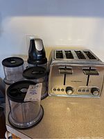 Hamilton Beach stainless steel double toaster and Ninja chopper with four plastic containers on countertop.