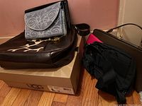 Photo showing multiple purses and the UGG box with boots inside