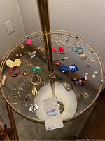 Photo of vintage earrings collection spread on glass table with mix of colors and styles