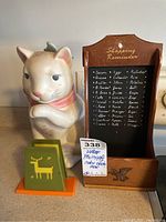 Photo showing all three items grouped on a kitchen counter: the cat cookie jar, shopping reminder rack with chalkboard, and napkin holder with reindeer design.