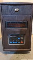 Front view of Garrison infrared heater showing digital control panel, wooden cabinet, and vented heater area.