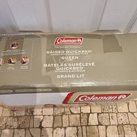 Close-up photo of product packaging showing Coleman brand and details of the queen size Raised Quickbed with electric pump.