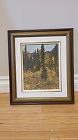 Frontal view of the framed unsigned oil painting showing autumn forest and mountain landscape.