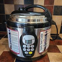 Front view of the pressure cooker showing Bravetti brand digital control panel with cooking options and timer display.