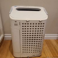 Front view of the Sharp air cleaner/humidifier/dehumidifier showing vented side panel with a handle on top.