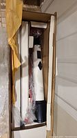 Full view of telescope in its packaging, showing white optical tube with black mount and some packing materials.