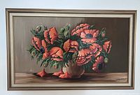 Full view of the framed oil painting showing the vibrant red flowers and the signature on the lower right.