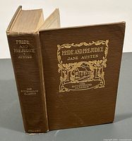 Front and spine view of Pride and Prejudice book showing brown cloth cover with gold embossed text and design.