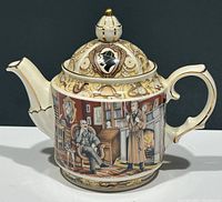 Full side view of the Sherlock Holmes themed ceramic teapot showing the illustration of Holmes and Watson next to a fireplace and bookshelf, detailed gold trim, decorated lid with Sherlock Holmes silhouette emblem.
