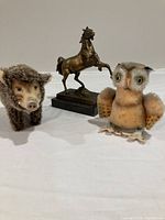 All three animal figurines: bronze horse statue, Steiff wild boar plush and owl plush figurines.