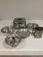 Front view of all baking items including vintage sifter and cake plate with cover.