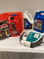 Photo showing the full lot: 15-foot drain snake coiled with packaging in front, grouped with four bottles/packs of drain cleaning chemicals (Drano, Zep, Roto-Rooter) on white surface.