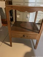 Cherry hardwood nightstand with one small drawer, natural wood finish.