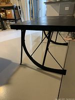 Side close-up of the metal sleigh runner base showing the curved runner shape and cross supports.