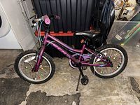 Photo of a 16-inch purple CCM children's bicycle with colorful spoke decorations, black seat, and pink grips.
