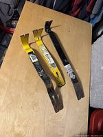 Three metal pry bars on wooden surface, showing size and condition